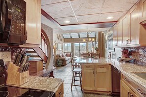 Enjoy meals in this kitchen with a central island, microwave, and dining area with a bench and outdoor views.