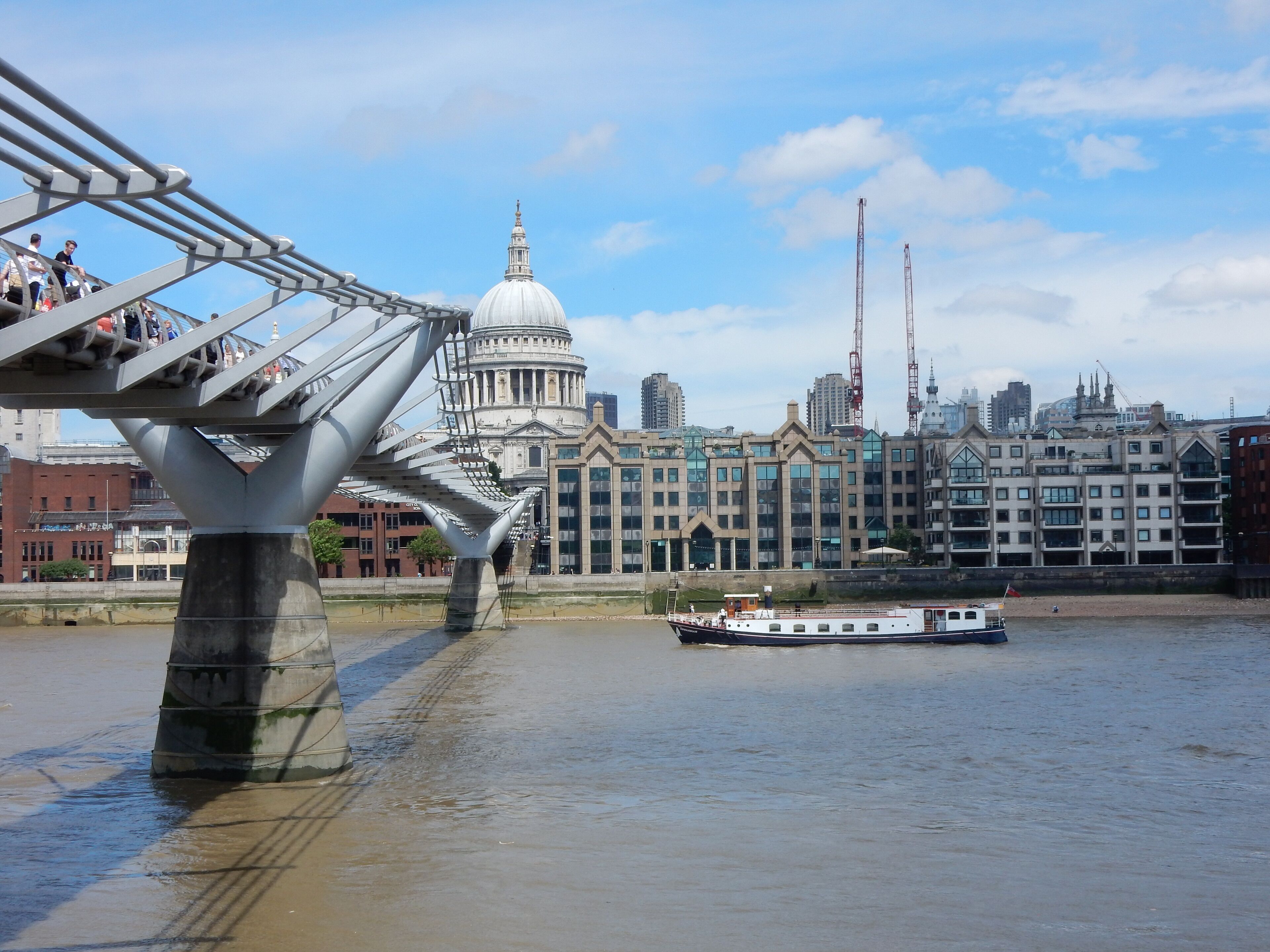 A river with a boat, a bridge, and a historic building in the background.