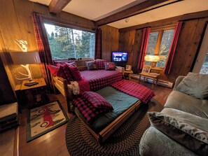 A cozy cabin room with a large bed, a television, and a fireplace. - Cozy, comfy, rustic ski chalet at the foot of Ski Brule ski mountain (Iron River)