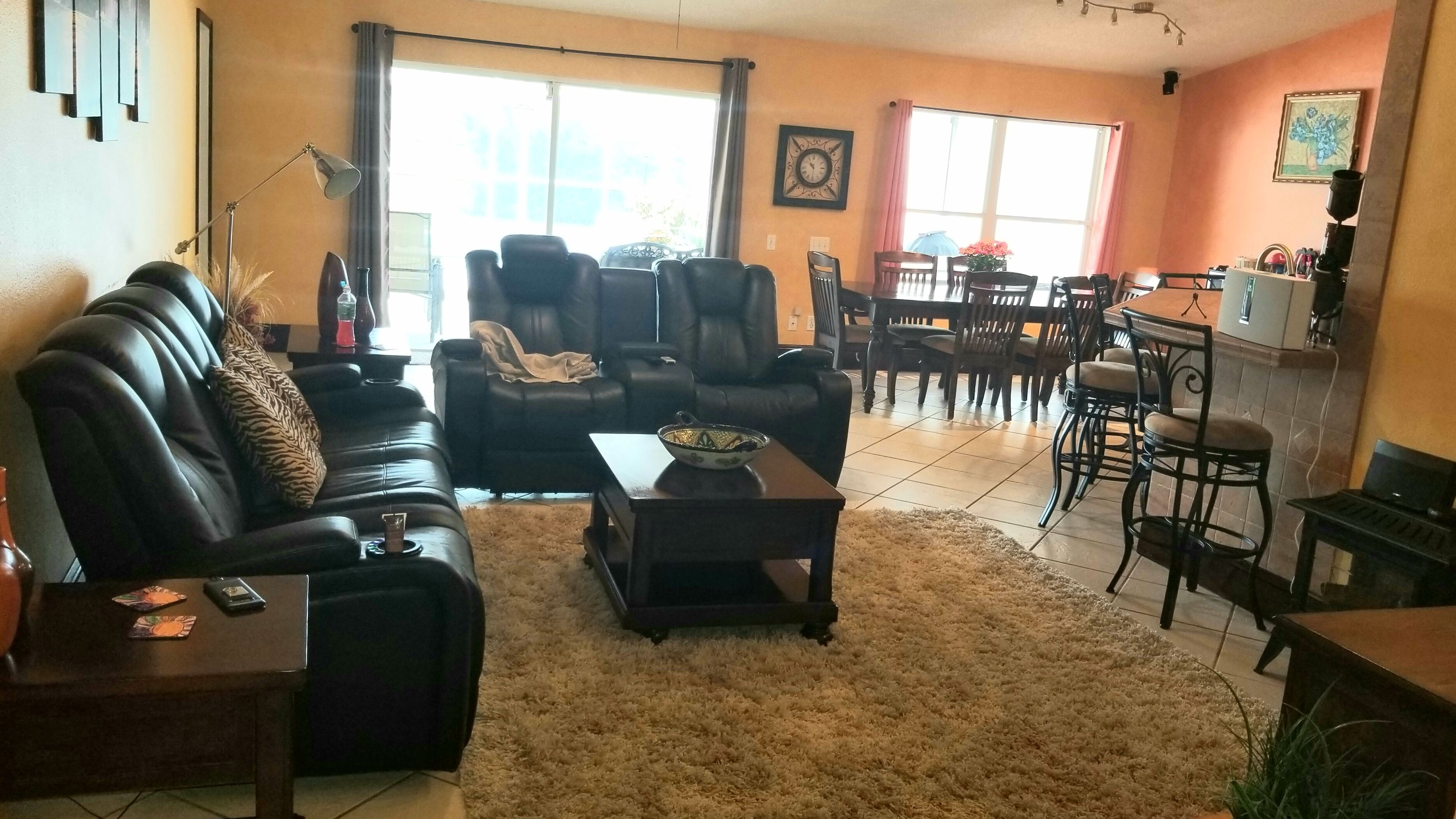 A living room with a sofa, chairs, a coffee table, and a dining area with a table and chairs.