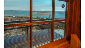 Una habitación con un amplio ventanal con vista a una playa y al agua.
