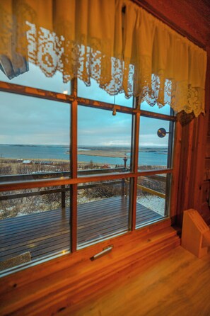 Una habitación con un amplio ventanal con vista a una playa y al agua.