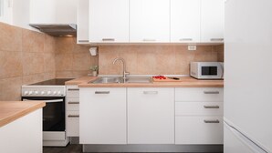 A modern kitchen with white cabinets, a stainless steel sink, a microwave, and a stove. - "City and Sea" apt in center, 5 min walk to the Diocletian’s palace and beach  (Split)