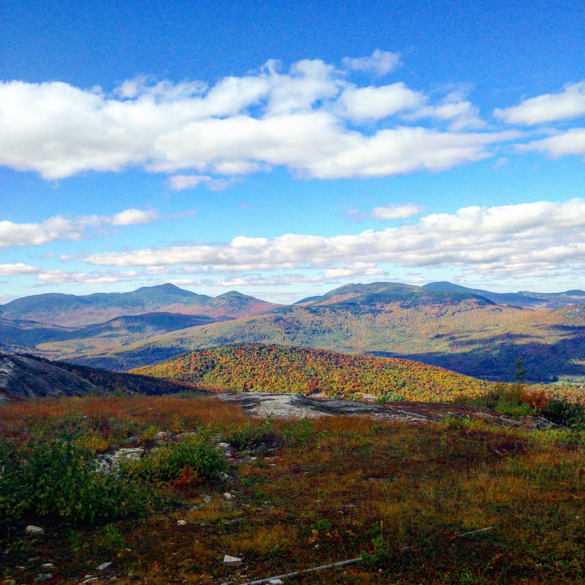 A mountainous landscape with autumn foliage and a clear sky.
