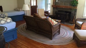 Uma sala de estar aconchegante com lareira, sofá, poltrona e um armário azul.