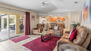 A spacious living room with a glass coffee table, leather sofas, and a ceiling fan. - LUXURY FOR YOU + Last-Minute-Rates: 2 Masters, Gas Grill, TV65" 4K & Game Room (Davenport)