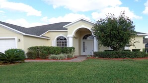A two-story house with a front entrance, a garage, and a well-maintained lawn. - LUXURY FOR YOU + Last-Minute-Rates: 2 Masters, Gas Grill, TV65" 4K & Game Room (Davenport)