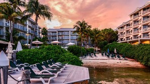 A resort with a wooden dock, lounge chairs, and a beach area. - Galleon Resort Efficiency in the old town (Key West)