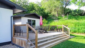 A wooden deck with outdoor furniture, a small covered area, and a staircase leading to a building. - Charming Lake House within Walking Distance from Lake (Yankton)