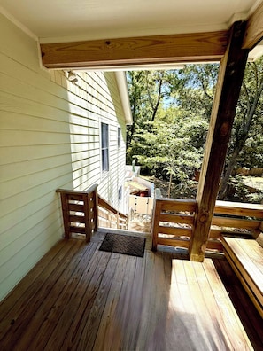 A wooden deck with a view of a house and trees. - Escape to the Beech House: A Wooded Family- Friendly Retreat Close to the Beach! (Kitty Hawk)