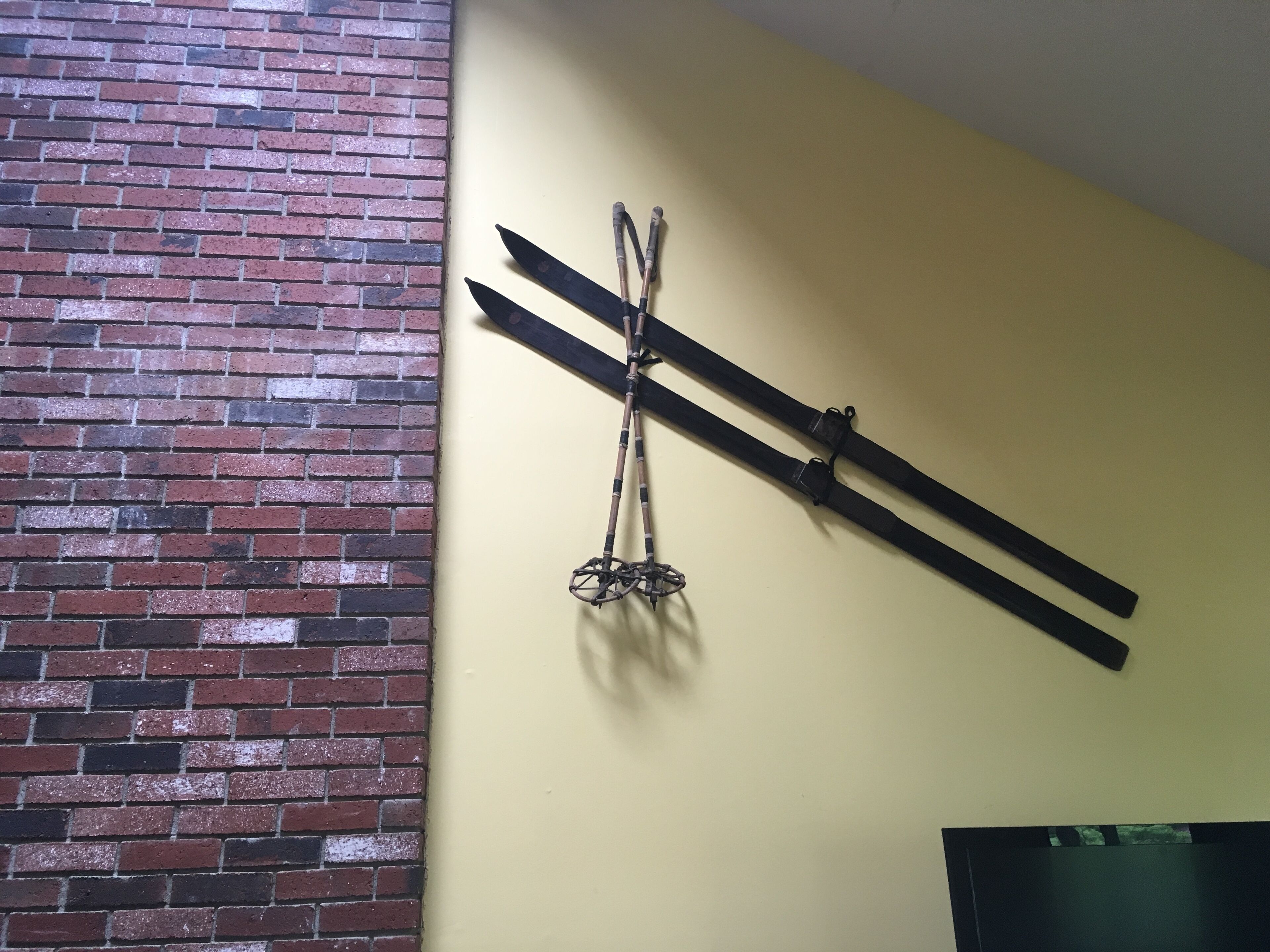 A room with a brick wall and a mounted wooden structure.