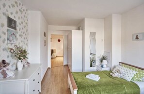 Una camera da letto con un letto, una panca, una cassettiera e un comodino.