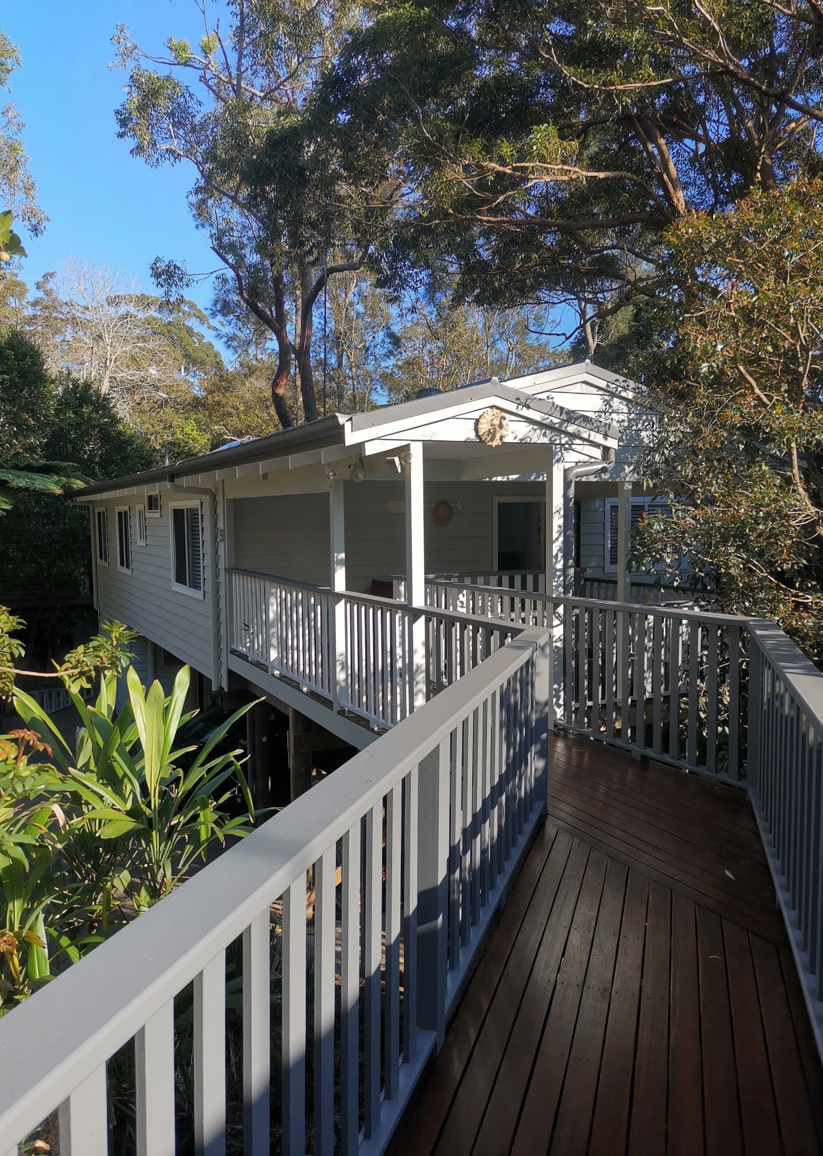 A two-story house with a wooden deck and white railings.