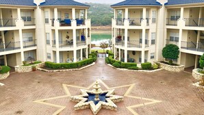 A multi-story hotel with a central courtyard featuring a star-shaped fountain. - STUNNING views of LAKE TRAVIS @ The Island (Lago Vista)