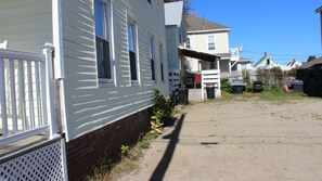 Homes with white siding and brick foundations feature front porches and multiple windows.