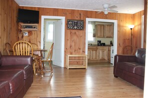 Relax in this inviting living space with a sofa, dining table, and flat-screen TV.