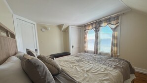 Ein Schlafzimmer mit einem Bett, einer Bank und einer Tür.