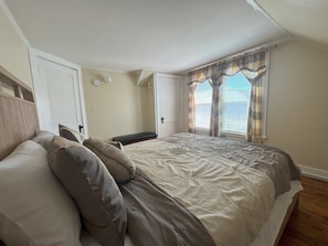 Cozy retreat with a large bed, bedside table, and window with curtains.