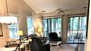 A spacious living room with a large window, a ceiling fan, and a view of the outdoors. - Best of Pawleys Plantation!   Inviting Retreat for Golfers and Beach Lovers (Pawleys Island)