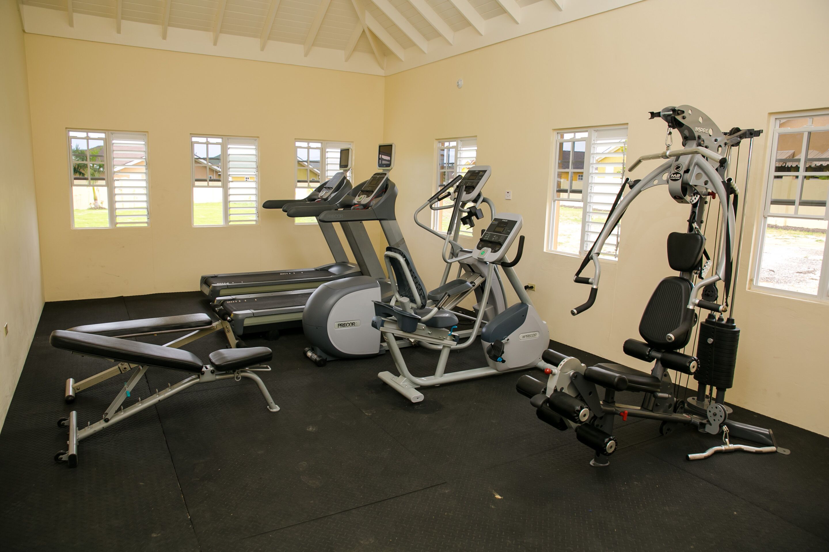 A gym with treadmills, an elliptical, and a weight machine.
