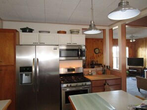 Una cocina compacta con electrodomésticos de acero inoxidable, armarios de madera y un comedor con mesa.