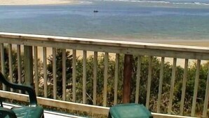 Een balkon met uitzicht op de oceaan en het strand.