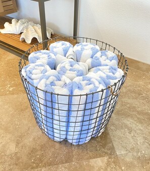 Ein Metallkorb mit blauen und weißen Handtüchern.
