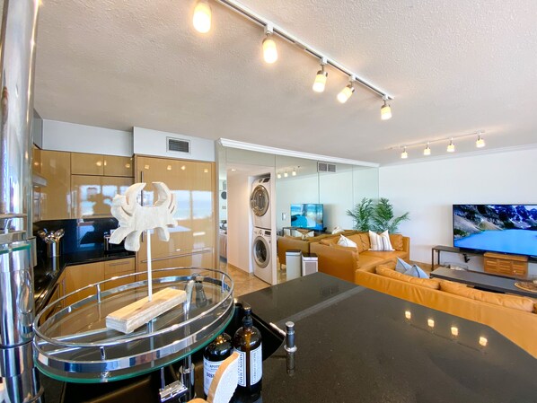 A modern living room with a sofa, a TV, and a glass-top coffee table.