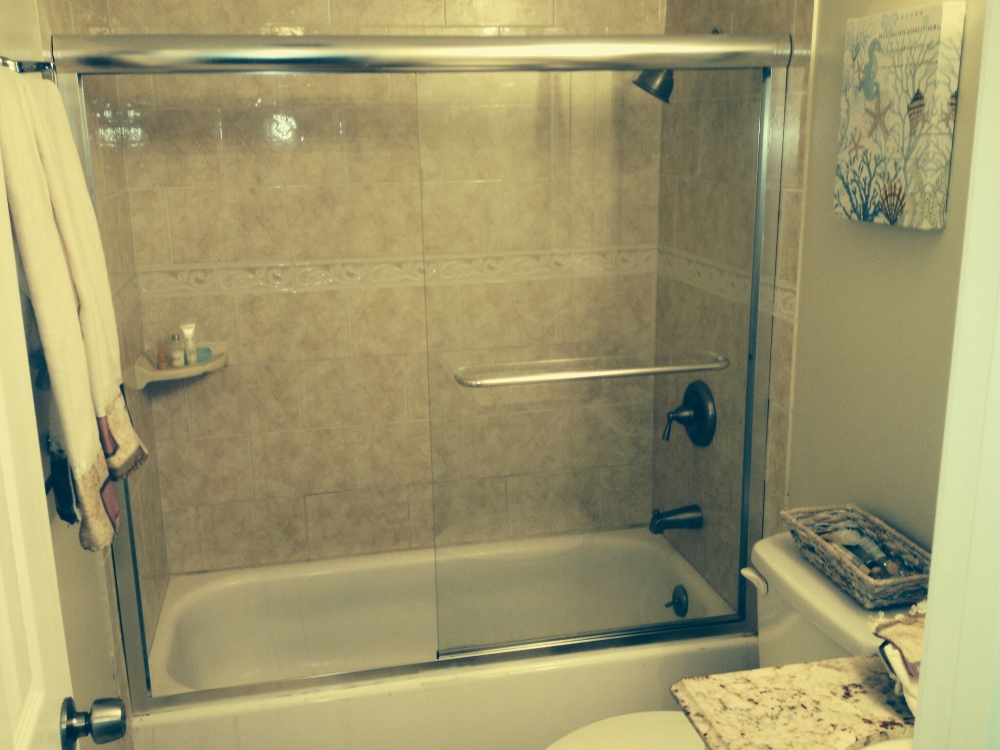 Un baño con ducha de vidrio, bañera y retrete.