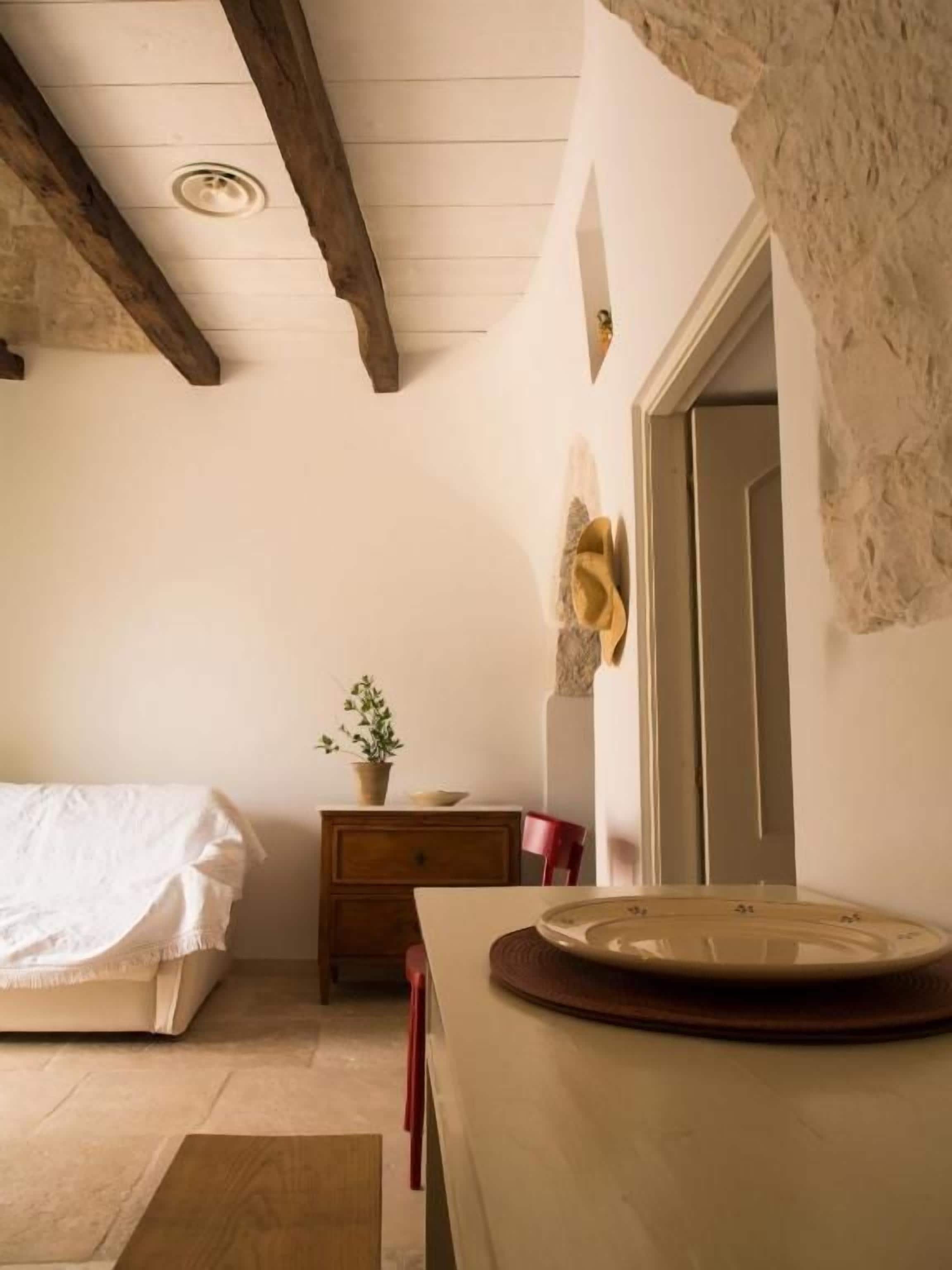 A bedroom with a bed, a dresser, a mirror, and a door.