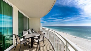 A balcony with a table and chairs, overlooking a beach with the ocean and a clear sky. - *Open ~  Oct 30 - Nov 5th!*  Beautiful gulf views! (Panama City Beach)