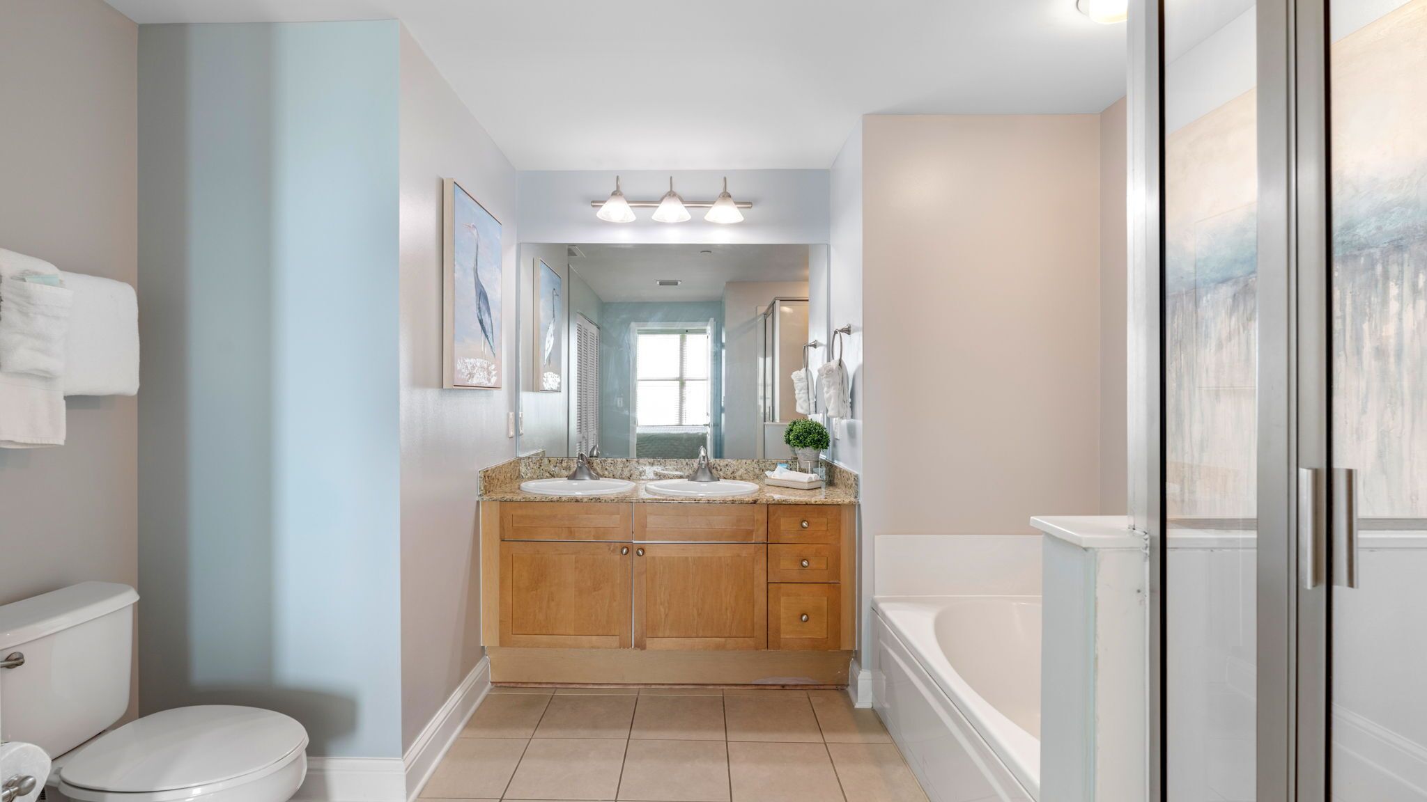 Une salle de bain moderne avec un meuble-lavabo à deux vasques, des toilettes et une baignoire.