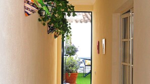 A narrow hallway with a door leading to a balcony.