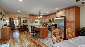 A spacious kitchen with wooden cabinets, a central island, and modern appliances.