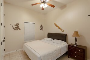 A bedroom with a bed, a nightstand, a lamp, and decorative wall art. - South Padre Island Spacious!!! 3 Bedroom 2 Bath #2015-837252 (South Padre Island)
