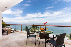 A balcony with a table set for a meal, overlooking the sea. - Best location right on los muertos beach, Sky Suite E (Amapas)