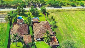 A coastal property with multiple buildings, a swimming pool, and a view of the ocean.