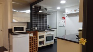 Une cuisine compacte équipée d’un four à micro-ondes, d’une cuisinière, d’un four et d’un réfrigérateur.