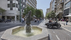 A public square with a fountain, pedestrians, and parked motorcycles. - Ermou Stylish viewing studio (Athina)
