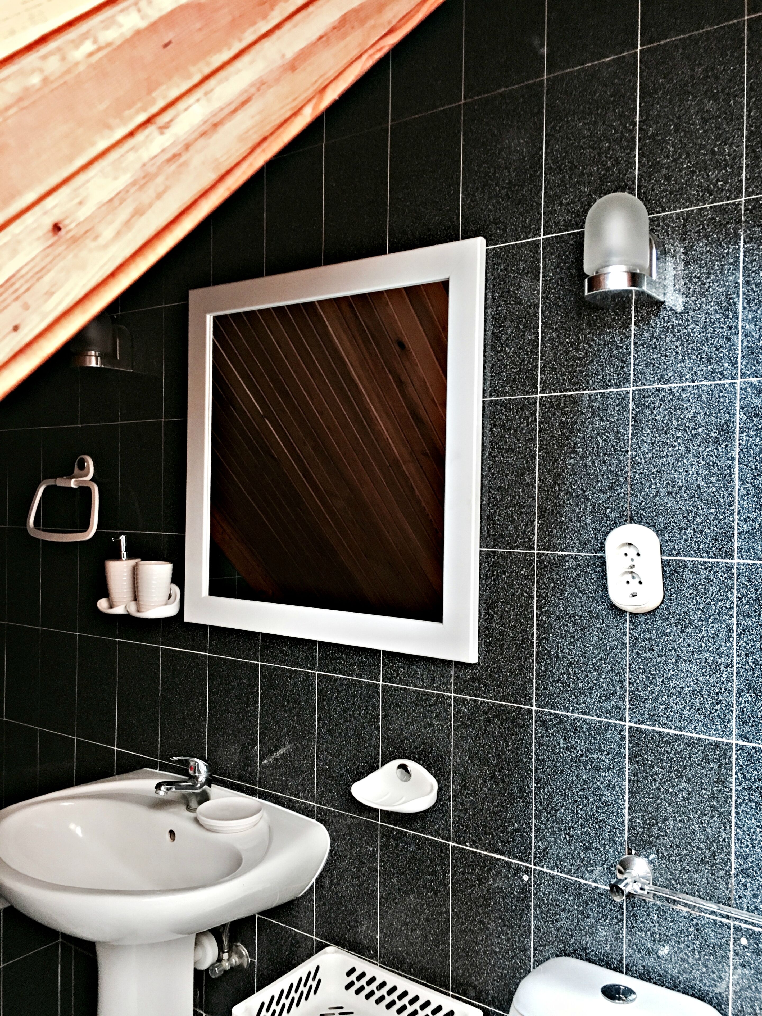 Une salle de bain équipée d’un lavabo, d’un miroir et d’un porte-serviettes.