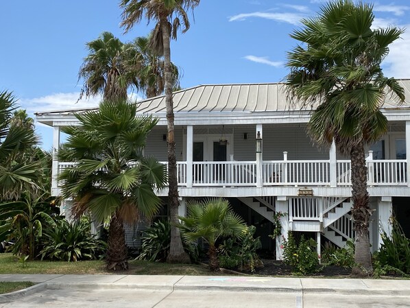 A two-story house with a balcony and a staircase leading to the upper floor.