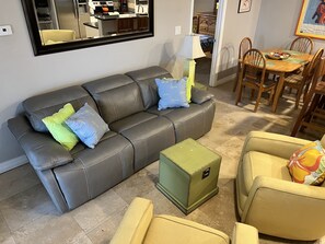 Relax in this stylish living space with a sofa, dining table, and mirror.