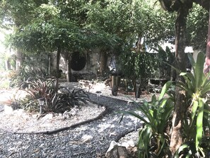 A garden with a gravel path, various plants, and a stone wall. - Ponce holiday apartment (Ponce)