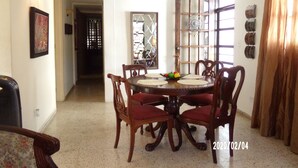 Un comedor con una mesa redonda, cuatro sillas y un adorno en la pared.