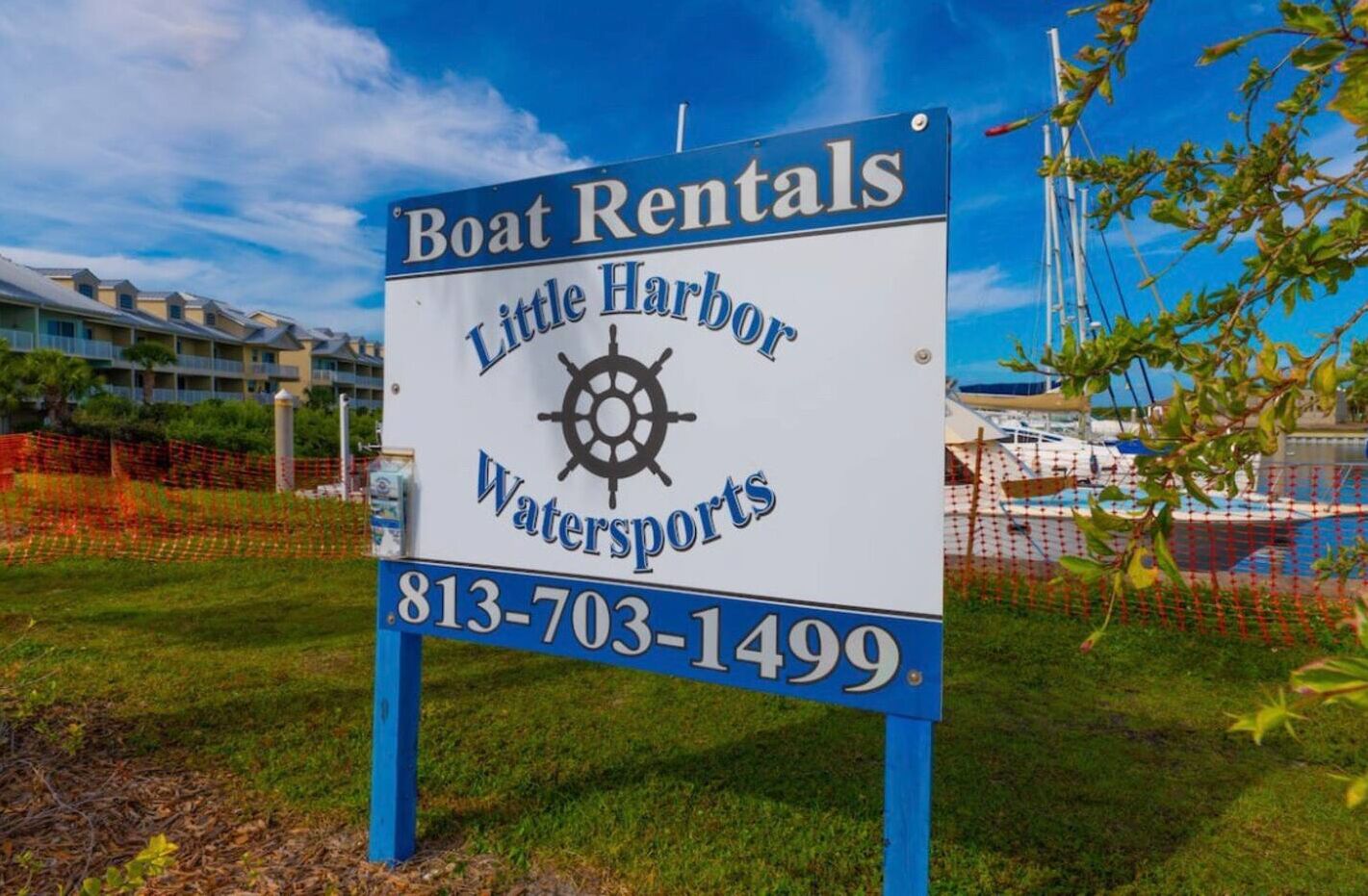 Une enseigne indiquant la location de bateaux chez Little Harbor Watersports, avec un numéro de téléphone à contacter.