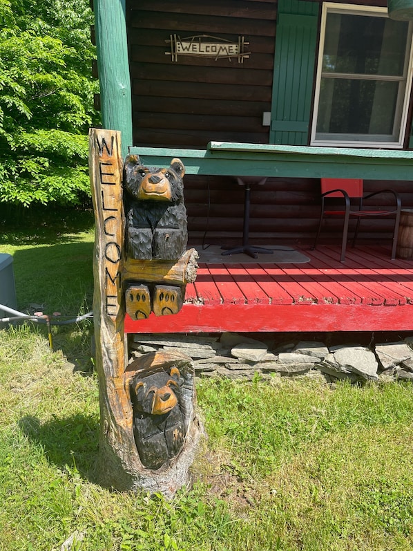 A wooden sign with "WELCOME" and two bear sculptures.