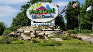 A sign for Margaritaville Lake Resort with a tropical theme, including palm trees and a blue bird.