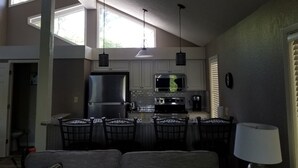 A kitchen with a dining area, a refrigerator, a microwave, and a stove.