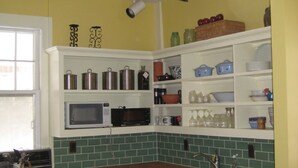 A kitchen with white cabinets, a microwave, a stove, and a sink.