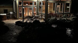 Eine Holzhütte mit großen Fenstern und einem steinbelagten Weg, der dorthin führt.
